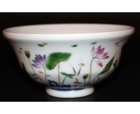 A CHINESE FAMILLE ROSE PORCELAIN BOWL, the sides decorated with a continuous scene of rockwork, lotus and other water foliage