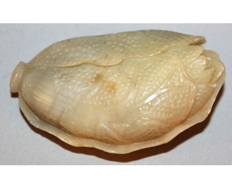 A CHINESE JADE PENDANT, in the form of a leaf-enshrouded plant with naturalistic engraved and stipple decoration, 2.3in high.