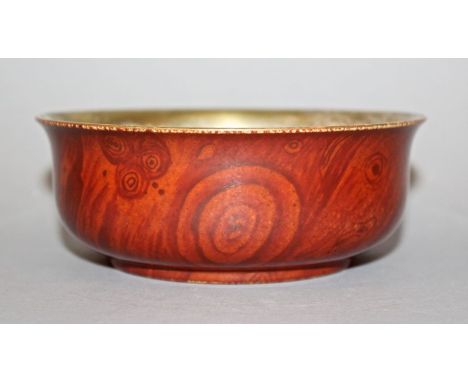 AN UNUSUAL CHINESE PORCELAIN BOWL, the glaze with wood grain decoration, the interior gilded, 5in diameter.