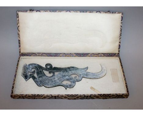 A 20TH CENTURY CHINESE ARCHAIC JADE-LIKE CARVING OF A DRAGON, of flattened form, together with a fitted patterned fabric box,