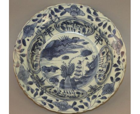 A CHINESE WANLI PERIOD BLUE & WHITE KRAAK PORCELAIN BOWL, circa 1600, painted to its centre with a river landscape scene encl
