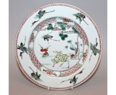 A GOOD CHINESE KANGXI PERIOD FAMILLE VERTE PORCELAIN PLATE, circa 1700, painted to its centre with a crane in flight above a 