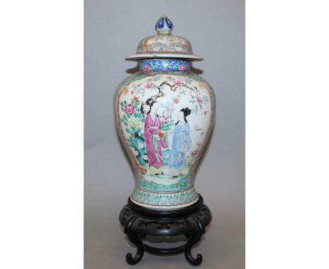 AN EARLY 20TH CENTURY JAPANESE FAMILLE ROSE PORCELAIN VASE & COVER, together with a wood stand, painted in a Chinese style wi