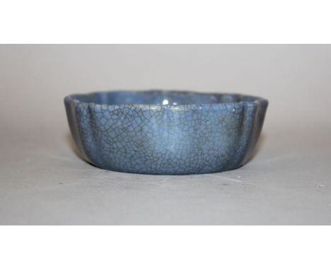 A CHINESE SHAPED PORCELAIN BOWL, applied with a blue crackled glazed, the base with a Qianlong seal mark, 4.4in wide.