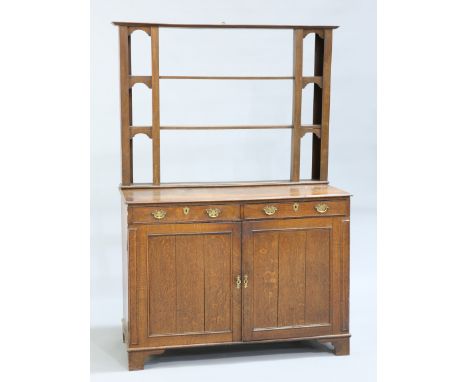 A GEORGE III DRESSER AND RACK, the open rack above a base with a pair of frieze drawers over a pair of cupboard doors, raised