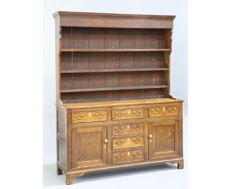 A GEORGE III OAK DRESSER AND RACK, the boarded rack with an ogee cornice and deep frieze above three shelves, the top with an
