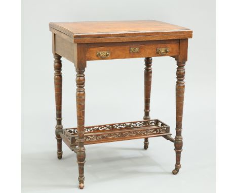 A LATE VICTORIAN MAHOGANY GAMES TABLE, the foldover top opening to reveal inlaid playing surfaces, over a frieze drawer, rais