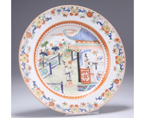 A CHINESE PORCELAIN PLATE,&nbsp;circular, decorated in an Imari palette with figures on a veranda within foliate and fruiting