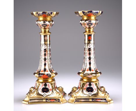 A PAIR OF ROYAL CROWN DERBY IMARI PATTERN CANDLESTICKS, pattern number 1128, with shaped drip trays, tapering columns and rai