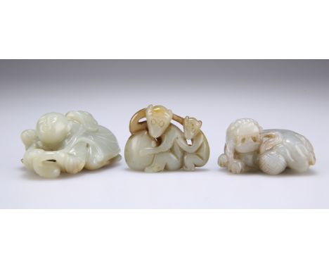 A GROUP OF THREE CHINESE JADE CARVINGS, the first carved as a crouching man holding a stem, the second depicting two monkeys 