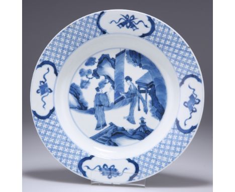 A CHINESE BLUE AND WHITE PORCELAIN PLATE,&nbsp;circular, painted to the well with two figures and a scroll, the broad rim pai