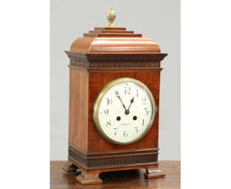 A MAPLE &amp; CO INLAID MAHOGANY MANTEL CLOCK, CIRCA 1900, the caddy top with brass acorn finial, above a dentil moulded corn