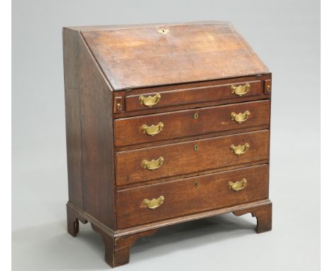 AN 18TH CENTURY OAK SLANT FRONT BUREAU, the hinged slope opening to reveal a fitted interior, above four long graduated drawe