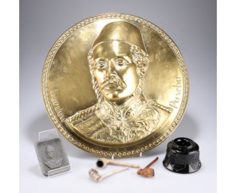 GENERAL GORDON OF KHARTOUM: A LARGE PRESSED BRASS WALL PLAQUE OF 'GORDON PASHA'; together with two clay pipes in his image; a
