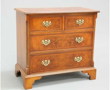 A GEORGIAN STYLE CROSSBANDED AND FEATHER BANDED BURR YEW CHEST OF DRAWERS, the moulded rectangular top above two short over t