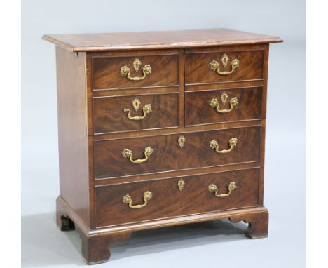 A GEORGE III STYLE MAHOGANY CABINET, the moulded rectangular top above two pairs of short drawer fronts hinged as cupboard do
