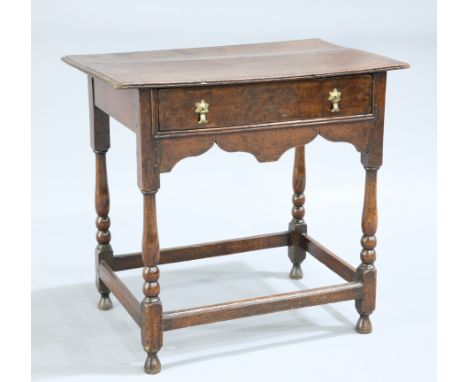 A QUEEN ANNE OAK SIDE TABLE,&nbsp;the moulded rectangular top above a frieze drawer with brass drop handles over a shaped apr