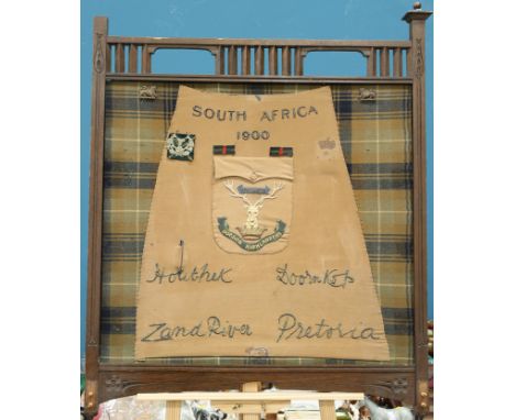 A WOODEN FIRESCREEN PANEL, THE FEET REMOVED, DECORATED TO COMMEMORATE THE GORDON HIGHLANDERS IN SOUTH AFRICA 1900,&nbsp;the c