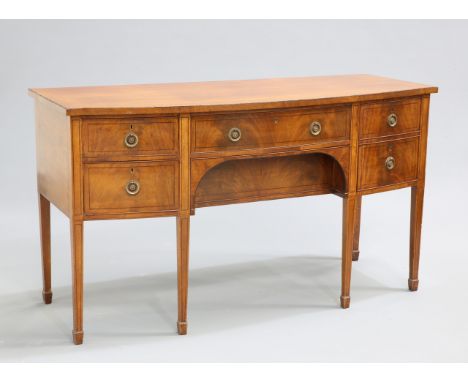 A REGENCY STYLE MAHOGANY BOW-FRONTED SIDEBOARD, fitted with an arrangement of drawers and cupboard door, all with brass ring 