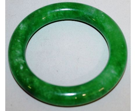 A CHINESE GREEN JADE-LIKE BANGLE, 3.1in diameter.