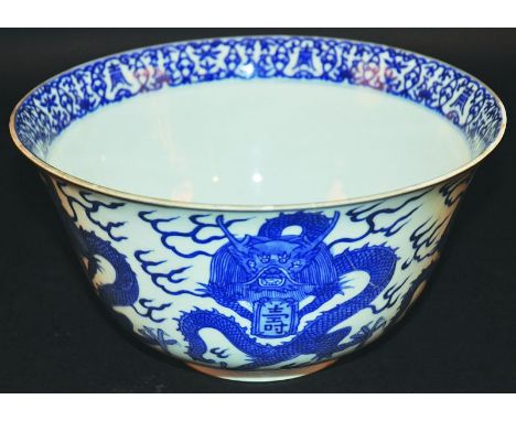 AN UNUSUAL CHINESE 17TH/18TH CENTURY BLUE & WHITE PORCELAIN BOWL, the sides painted with repeated coiled dragons clasping an 