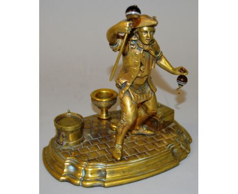 A GOOD BRASS TABLE STAND with a man holding onyx stick and hook, box and other objects on the base. 7ins high.