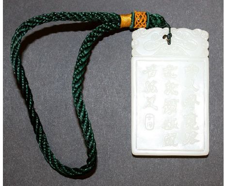 ANOTHER CHINESE WHITE JADE-LIKE PENDANT, with attached tassel, the pendant decorated to its front with a scene of a sage and 