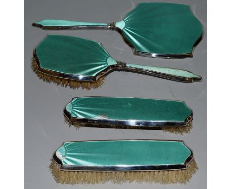 A SILVER AND ENAMEL DRESSING TABLE SET with mirror and three brushes.