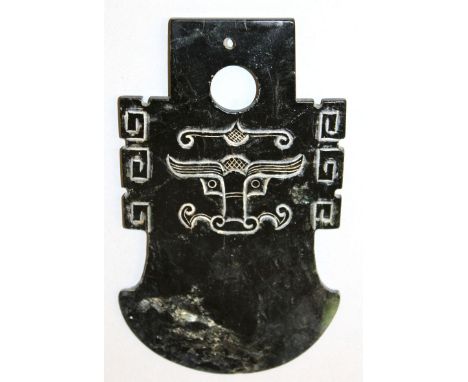 ANOTHER 20TH CENTURY CHINESE JADE-LIKE AXE HEAD, yue, carved with taotie masks and key-fret borders, the stone of predominant