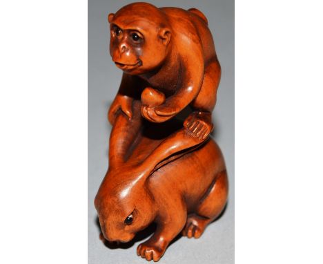 A BOXWOOD CARVED NETSUKE, A MONKEY ON A RABBIT’S BACK, signed.