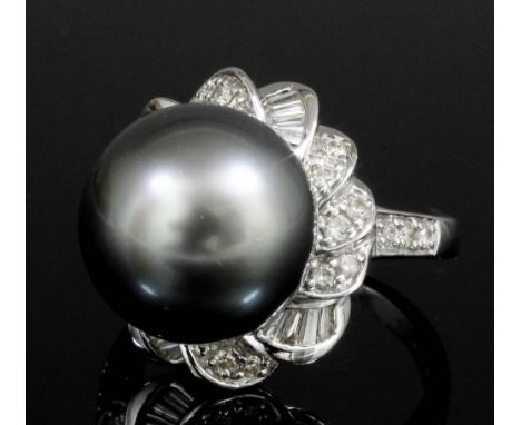 A modern 18ct white gold, black pearl and diamond set ring, the 12mm black pearl within scrolling diamond borders set with el