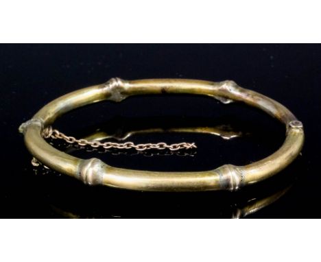 A late Victorian gold coloured metal stiff bangle of "Bamboo" design, internal measurement 60mm x 50mm (gross weight 17 gramm