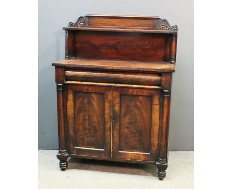 An early Victorian mahogany chiffonier, the upper part with open shelf, on turned supports, fitted cushion moulded frieze dra