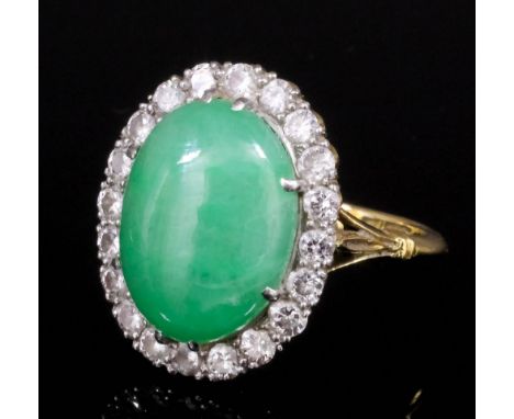 A modern 18ct gold and platinum mounted jade and diamond ring, the central oval cut cabochon stone approximately 4ct, contain