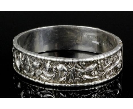 A Chinese silvery metal hinged stiff pattern bangle, the central panel cast with fish, sea shells and seaweed within bamboo p