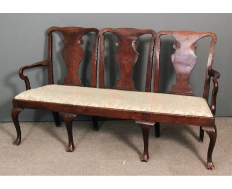 A walnut framed triple chair-back settee of George II design, the shaped crest rails with solid vase pattern splats, shepherd