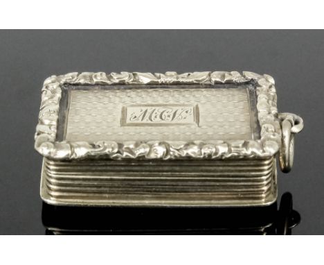 A William IV silver gilt rectangular vinaigrette, the engine turned lid with cast leaf scroll pattern mount, reeded sides and