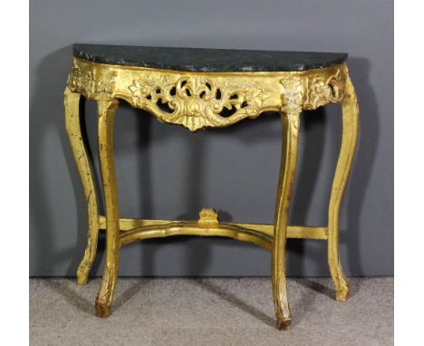 A 20th Century gilt console table of shaped outline, with green flecked marble top, the frieze fretted and carved with scroll