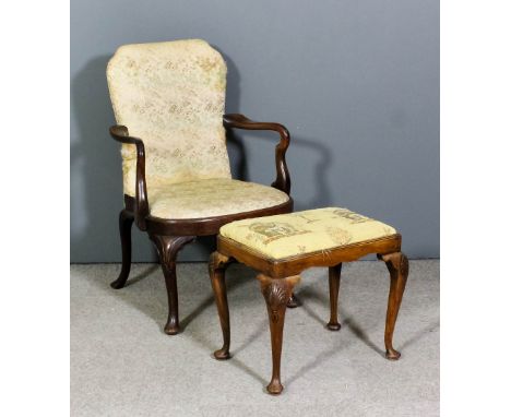 A walnut armchair of "Queen Anne" design with shepherd's crook arms, the back and seat upholstered in leaf tapestry, on cabri