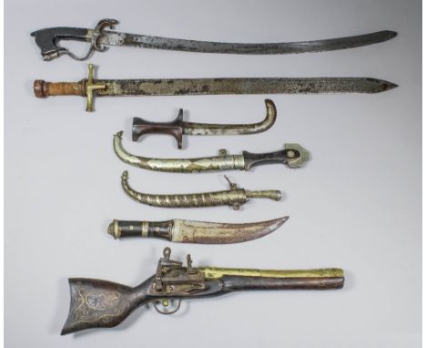 Three North African Kinjal style daggers, one short sword, the 25ins steel blade with etched stylised Islamic characters, and