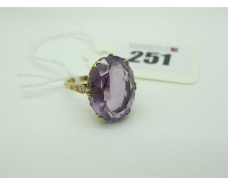 A Large Single Stone Dress Ring, oval double claw set, between textured shoulders (finger size O). 