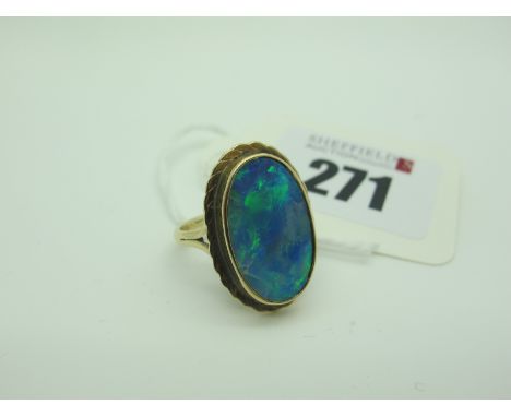 A Large Black Opal Doublet Oval Panel Ring, collet set between bifurcated shoulders (finger size N). 