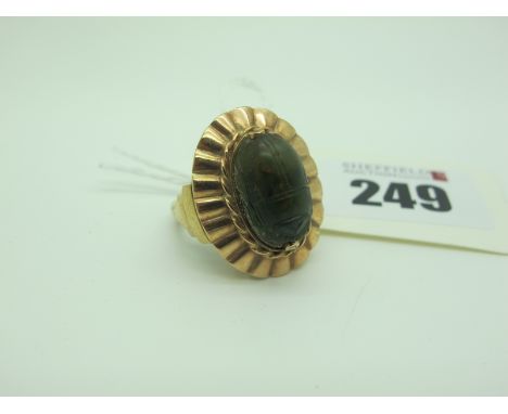 An Egyptian Scarab Beetle Dress Ring, oval set, within shaped setting and stepped shoulders (finger size M).