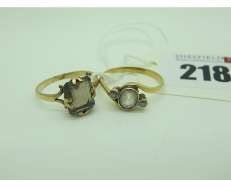 A 9ct Gold Single Stone Ring, claw set; together with a three stone ring of crossover design. (2) 