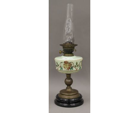 A Victorian oil lamp with painted green glass reservoir  