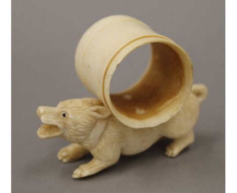 A bone napkin ring formed as a dog