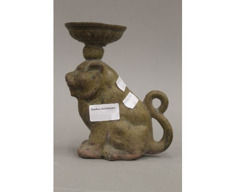 A Chinese porcelain oil lamp, modelled as a seated lion. 17 cm high