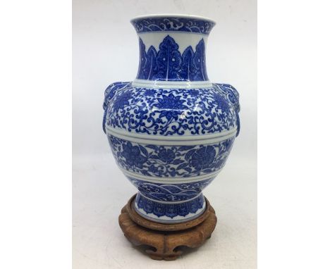 A Chinese blue and white twin-handled Zun vase, height 23.8cm, together with a stand.   Condition note: In very good all over