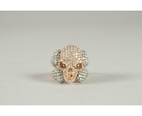 AN 18CT GOLD DIAMOND SET SKULL RING. 8.6gms.