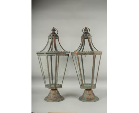 A PAIR OF METAL TAPERING LANTERNS with ring handles. 26ins high.